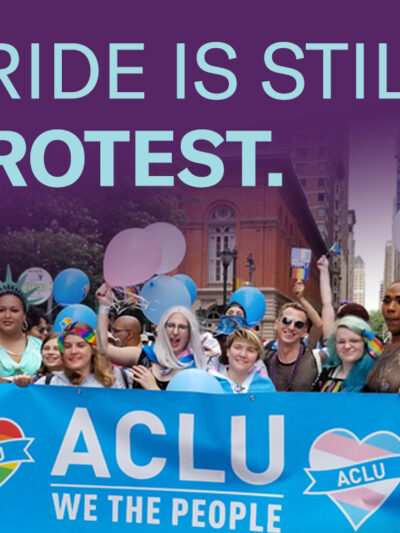 Philadelphia Pride attendees carry ACLU of PA banner to celebrate LGBTQ rights.
