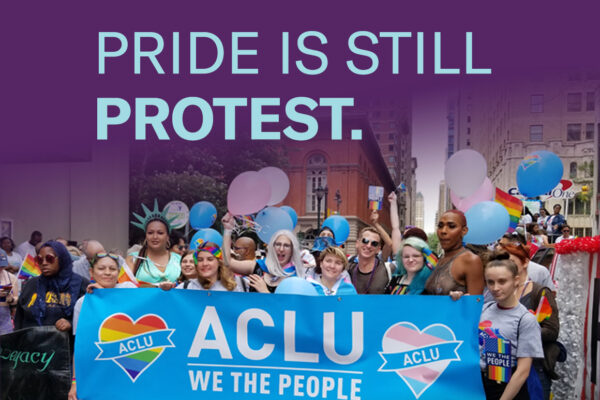 Philadelphia Pride attendees carry ACLU of PA banner to celebrate LGBTQ rights.