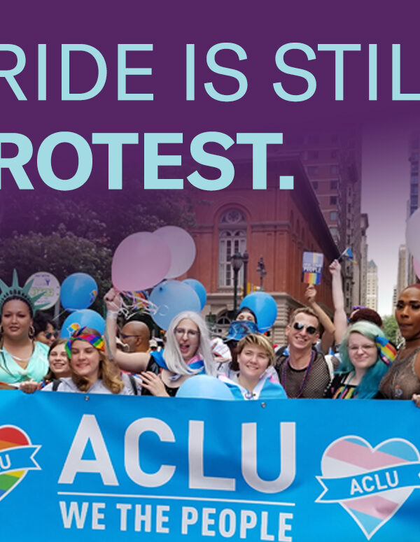 Philadelphia Pride attendees carry ACLU of PA banner to celebrate LGBTQ rights.