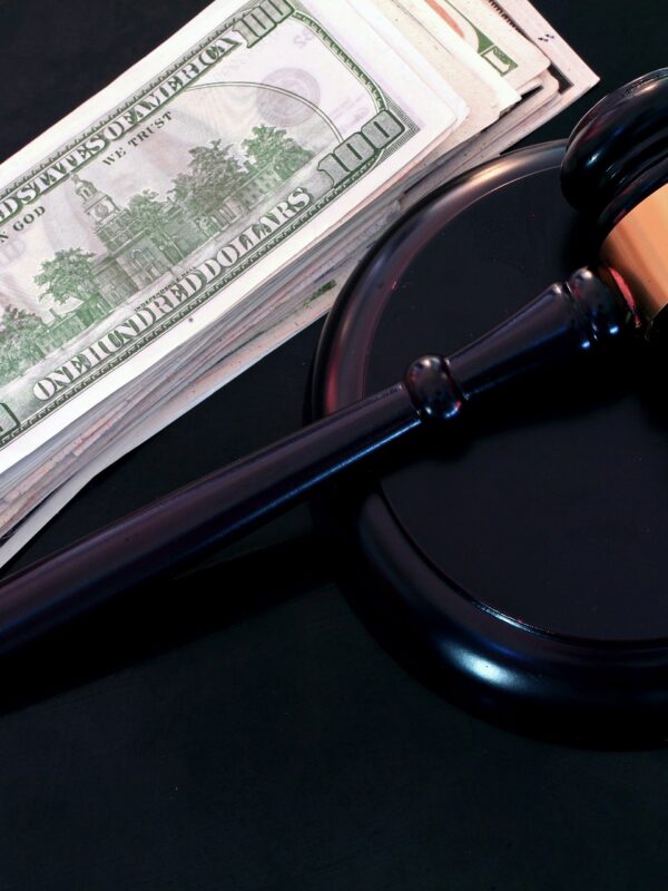stack of hundred dollar bills and a judge's gavel