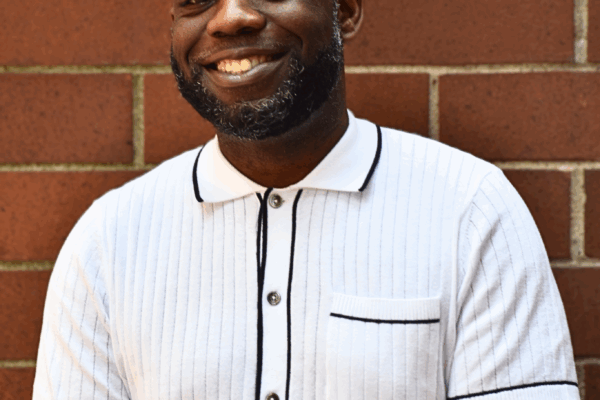 A picture of Tyree Williams smiling in a white and black button down shirt