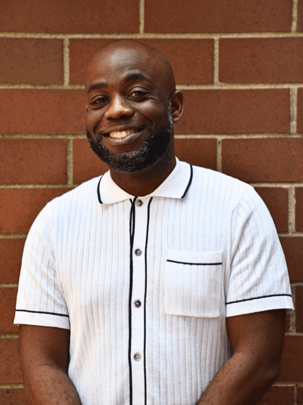 A picture of Tyree Williams smiling in a white and black button down shirt