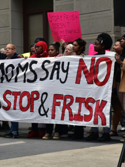 Group of demonstrators holding a banner reading "Moms say no to stop and frisk"