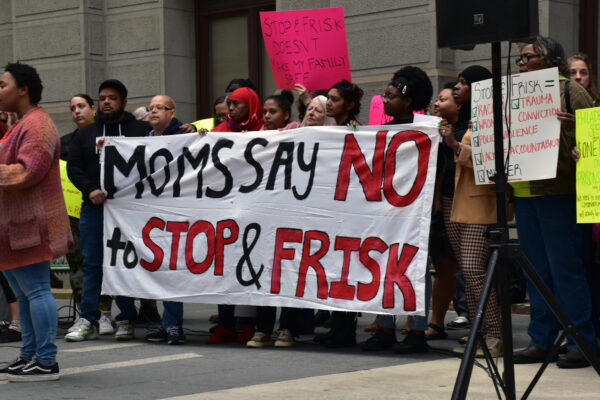Group of demonstrators holding a banner reading "Moms say no to stop and frisk"