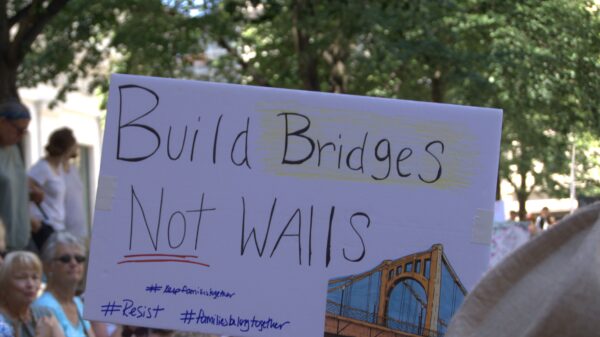 protest sign reading "Build Bridges, Not Walls"
