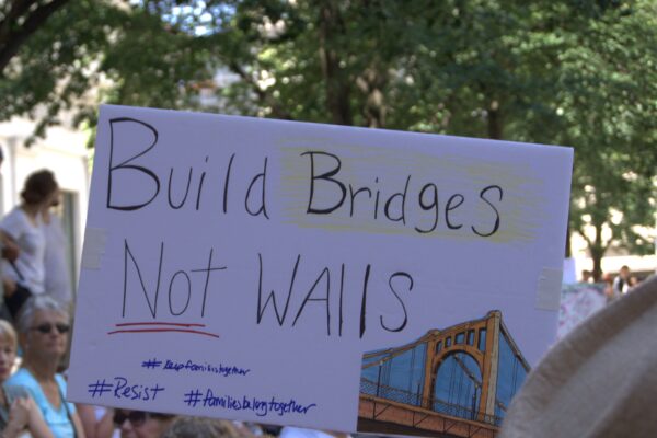 protest sign reading "Build Bridges, Not Walls"