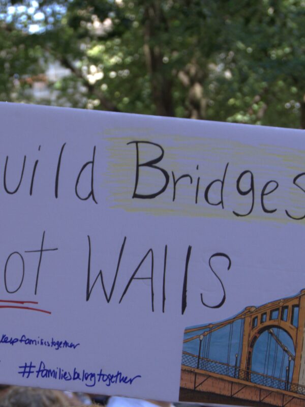 protest sign reading "Build Bridges, Not Walls"