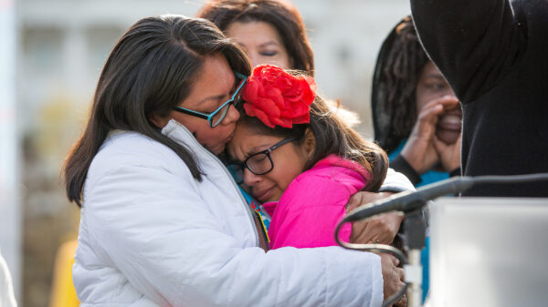 A woman holding her crying daughter outside