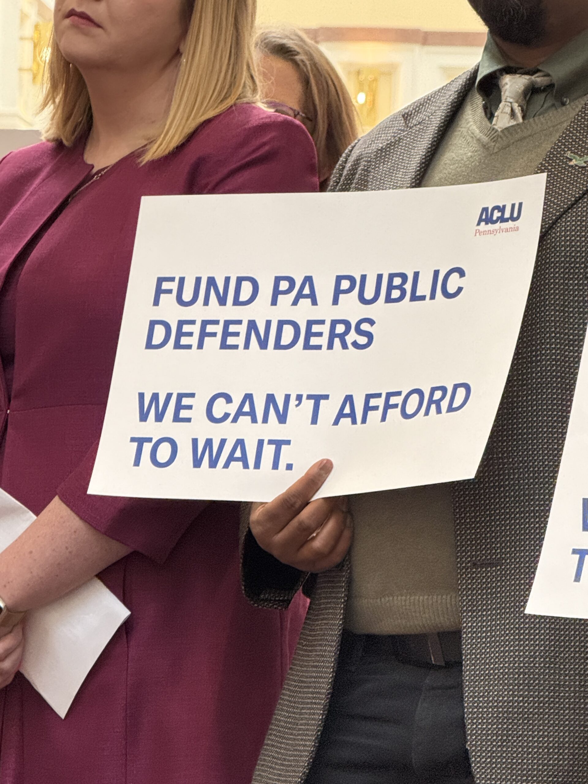 A picture of a sign that says, "Fund Pennsylvania public defenders. We can't afford to wait".