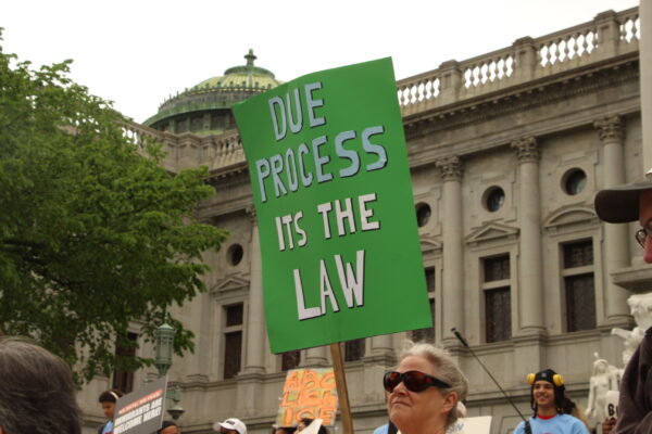 A picture of a green sign with text that says, "Due process. It's the law".