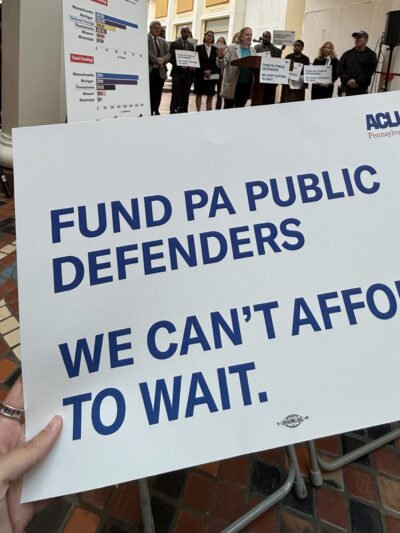 A photo of a sign that reads, “Fund PA public defenders. We can’t afford to wait.”