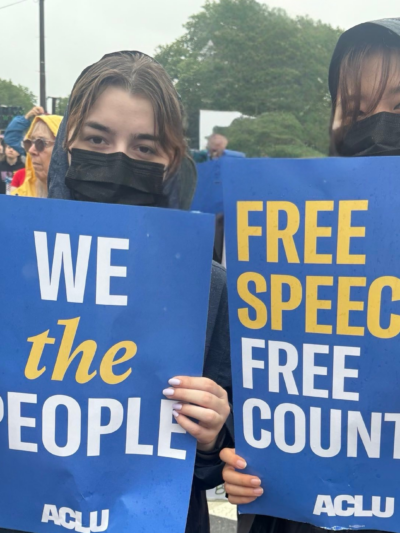 Two young people stand with protest signs.