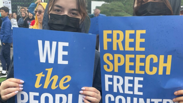 Two young people stand with protest signs.