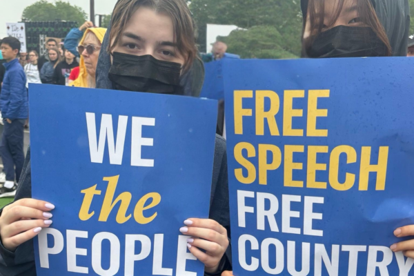 Two young people stand with protest signs.