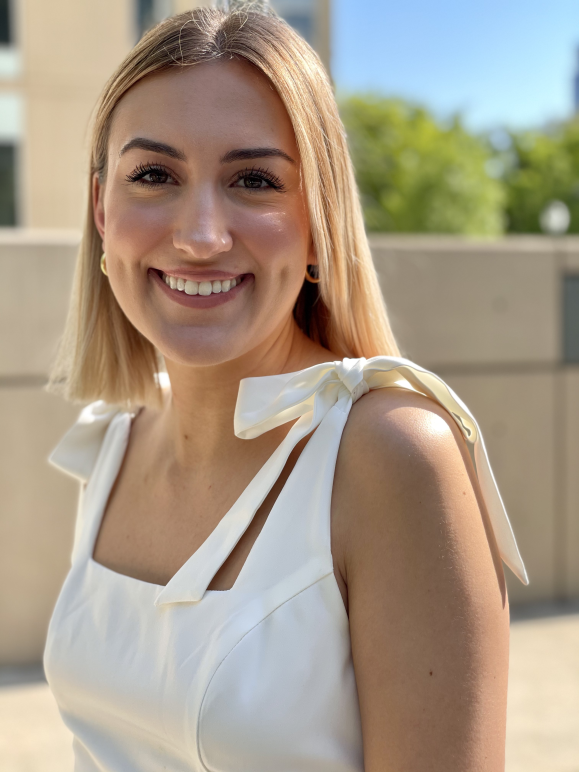 A picture of Sophia Schiaroli, smiling with short blonde hair and a white dress