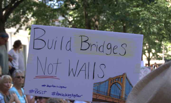 protest sign reading "Build Bridges, Not Walls"