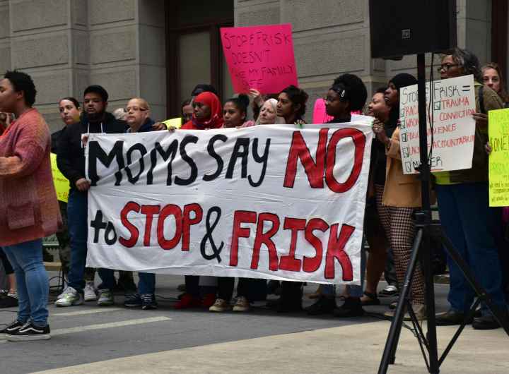 Group of demonstrators holding a banner reading "Moms say no to stop and frisk"