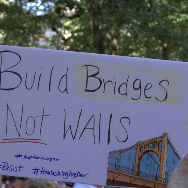 protest sign reading "Build Bridges, Not Walls"